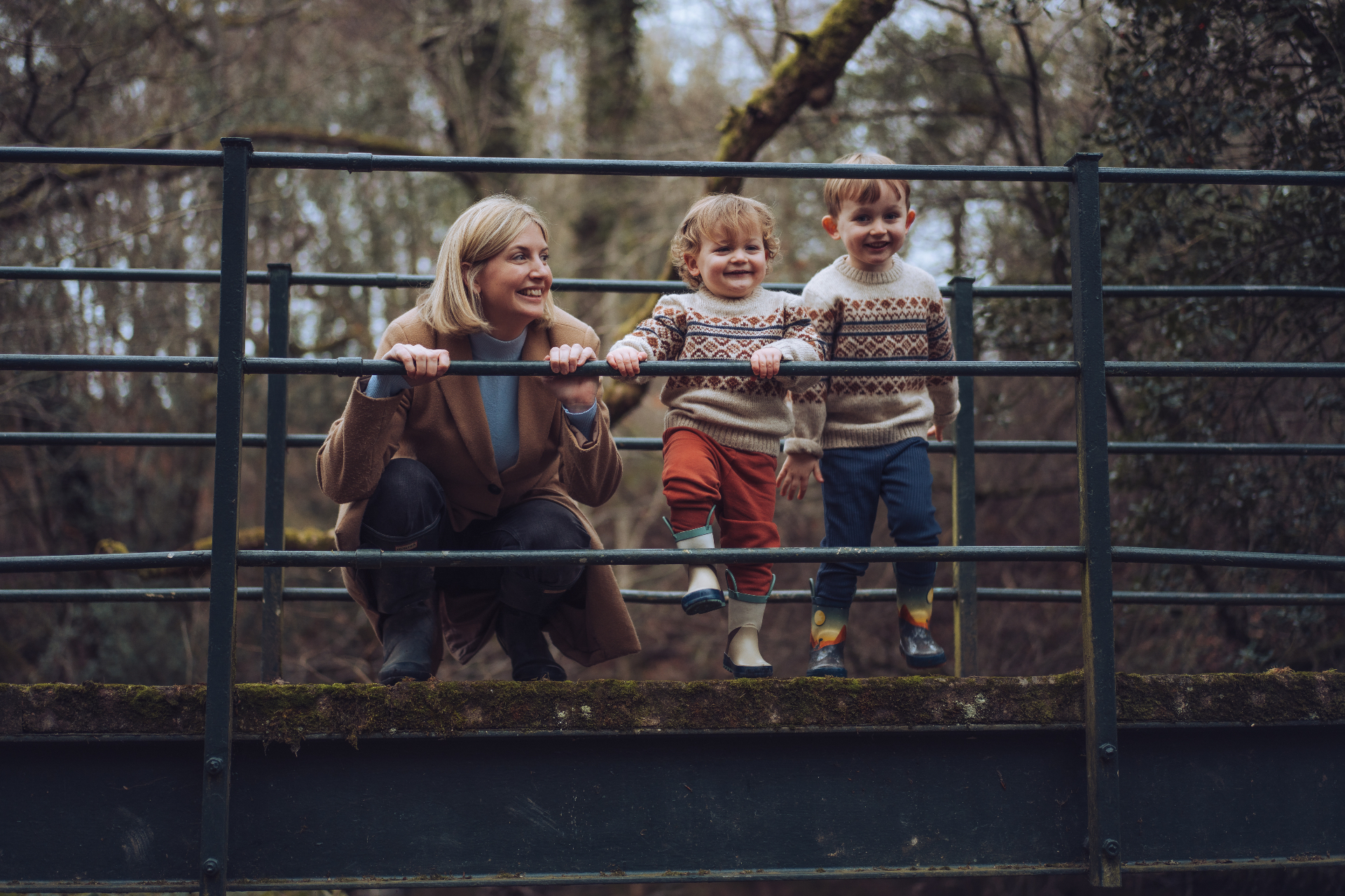 Kate Taylor on a woodland footbridge with her two young sons